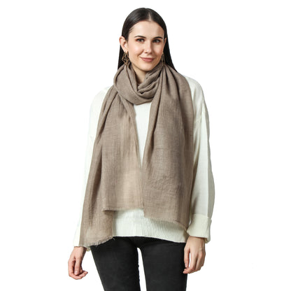 A woman elegantly wearing a Cashmere Scarf around her neck while the ends fall off her shoulder